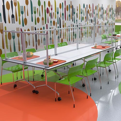 Clear perspex shield desktop dividers used to frame tables in a canteen space 